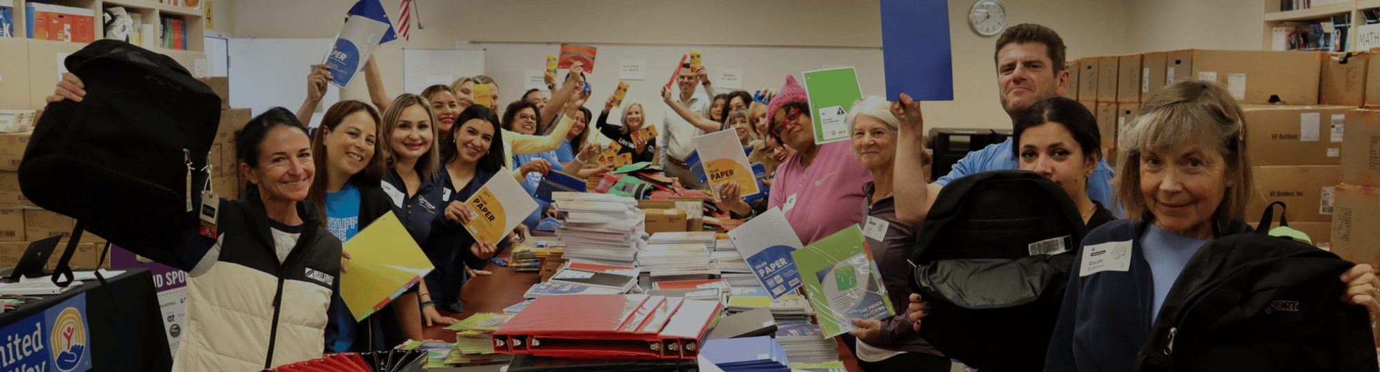vOLUNTEERS HOLDING UP SUPPLIES