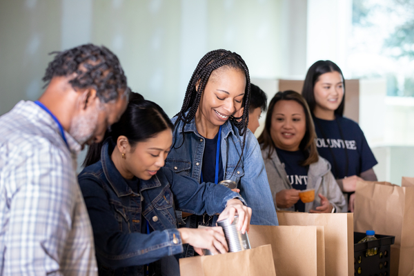Volunteers filling bags at a food drive.
